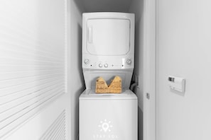 A compact, white washing machine with a control panel and a basket of laundry. - High Floor 2BR and 2 BA Free Parking (Hollywood)