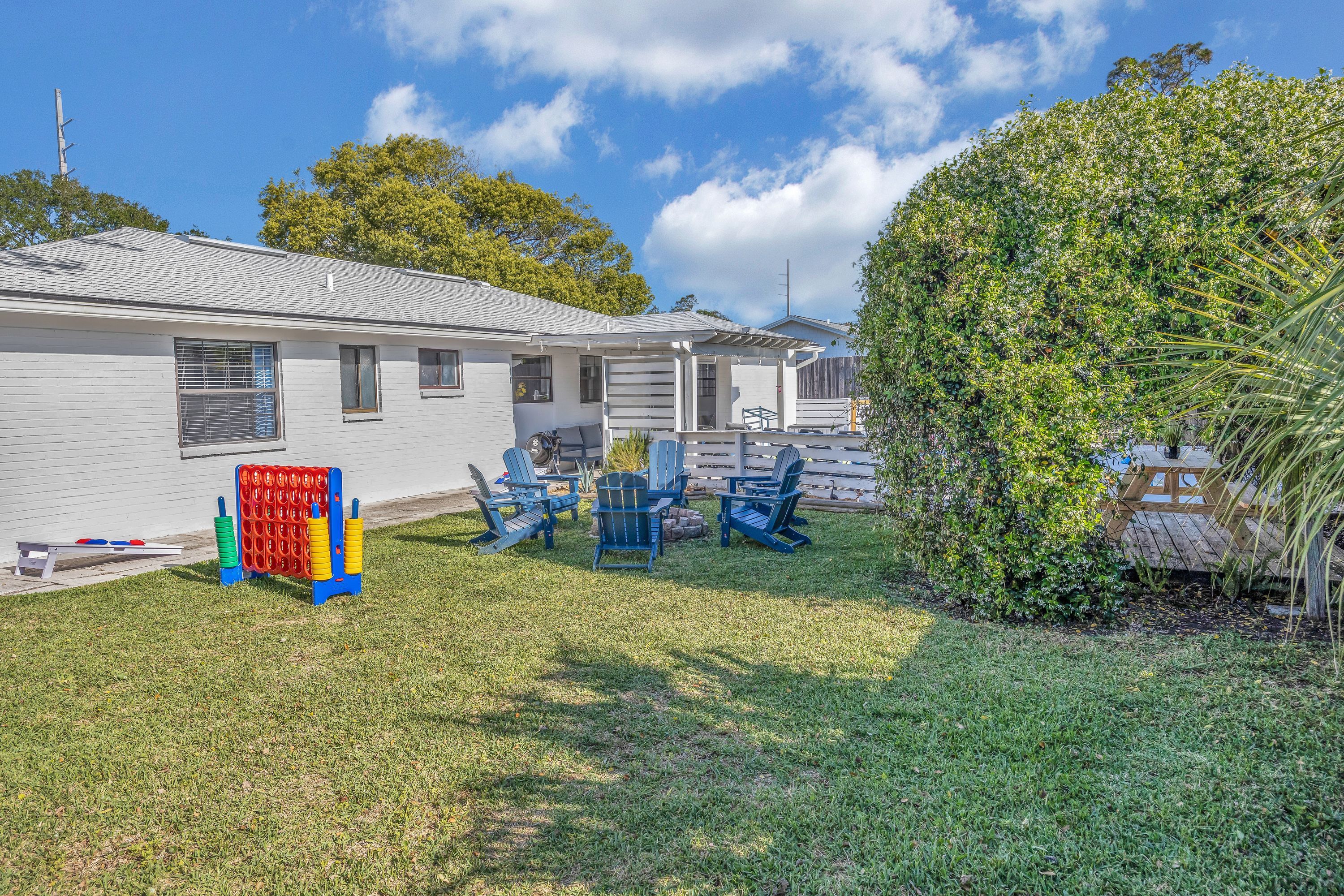 A residential property with a fenced yard, outdoor seating area, and a small deck.