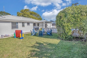 A residential property with a fenced yard, outdoor seating area, and a small deck.