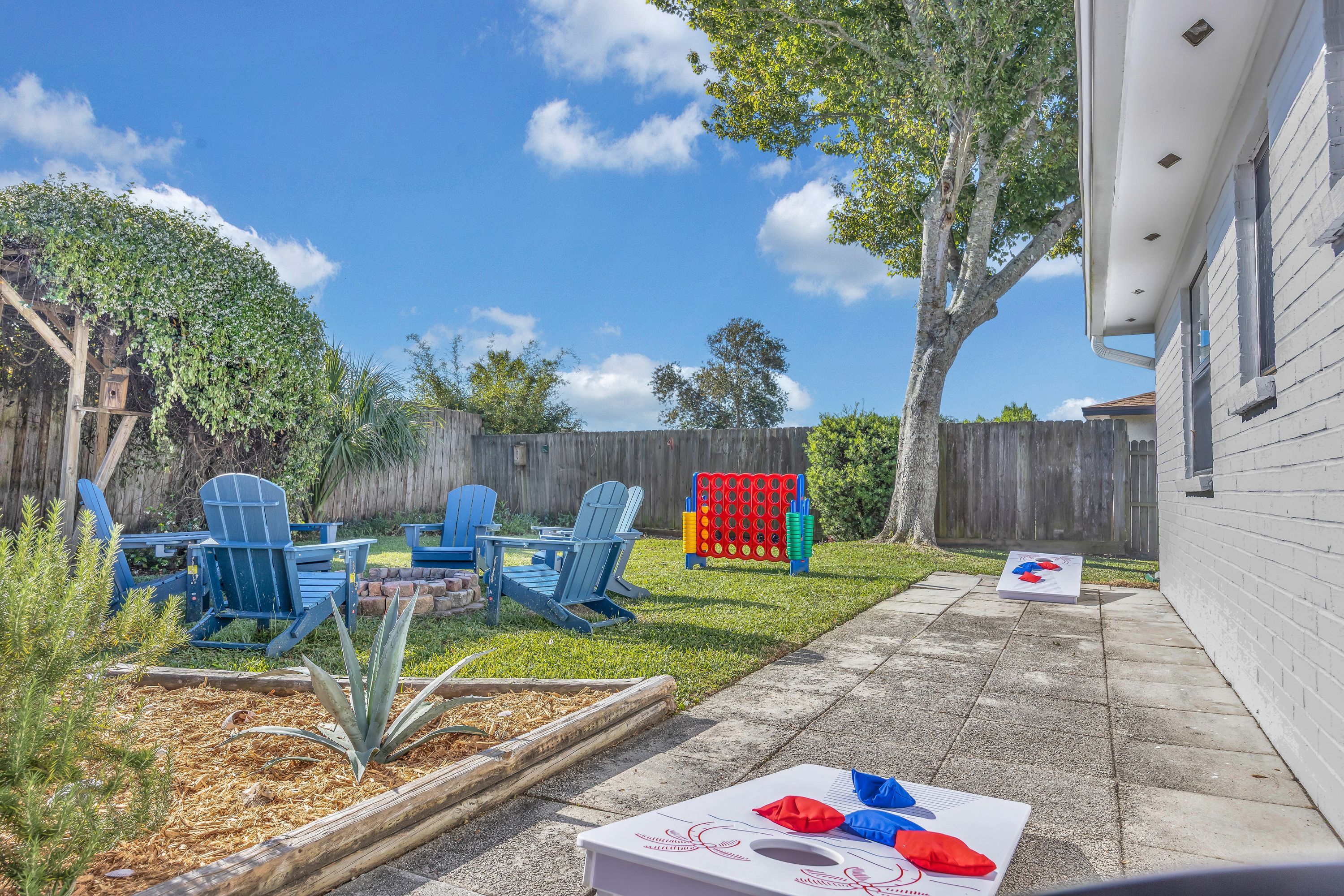 A backyard with a patio, outdoor seating, and a garden area.