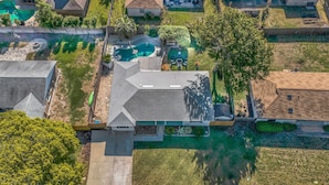 An aerial view of a residential area with houses, a swimming pool, and a well-maintained lawn. - Endless Summer- Beach Pool Firepit 3 King Beds (Ponte Vedra Beach)