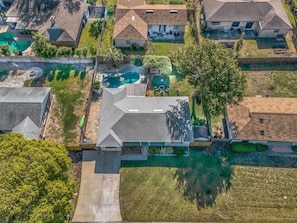 An aerial view of a residential area with houses, a swimming pool, and a well-maintained lawn. - Endless Summer- Beach Pool Firepit 3 King Beds (Ponte Vedra Beach)