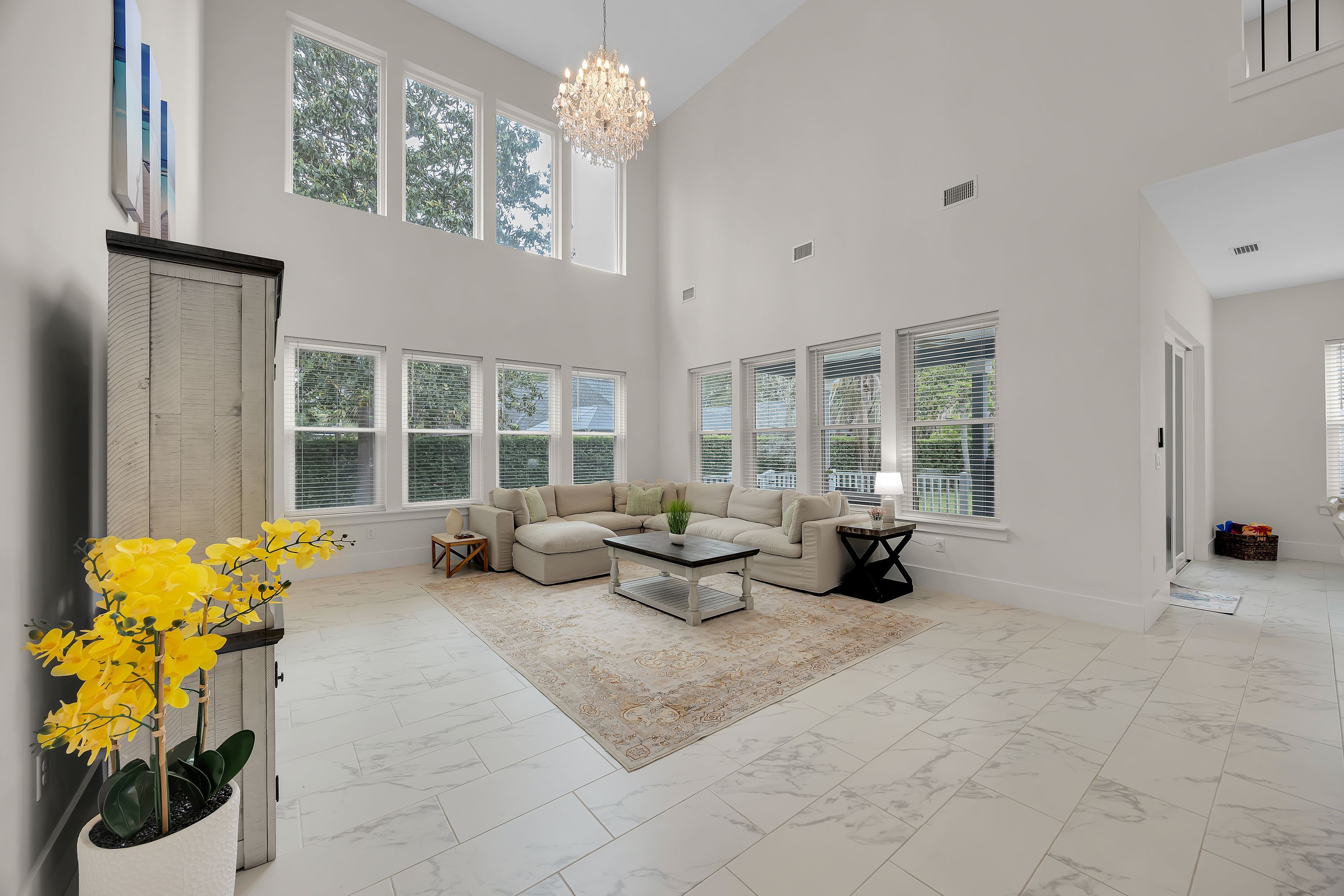 A spacious living room with a sectional sofa, a coffee table, and a chandelier.