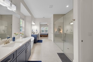 A modern bathroom with a walk-in shower, a large mirror, and a vanity with a sink. - Salt Air 6BR Game Room Walk to Beach Luxe (Ponte Vedra Beach)