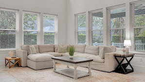 A spacious living room with a sectional sofa, a coffee table, and a side table. - Salt Air 6BR Game Room Walk to Beach Luxe (Ponte Vedra Beach)