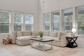 A spacious living room with a sectional sofa, a coffee table, and a side table. - Salt Air 6BR Game Room Walk to Beach Luxe (Ponte Vedra Beach)