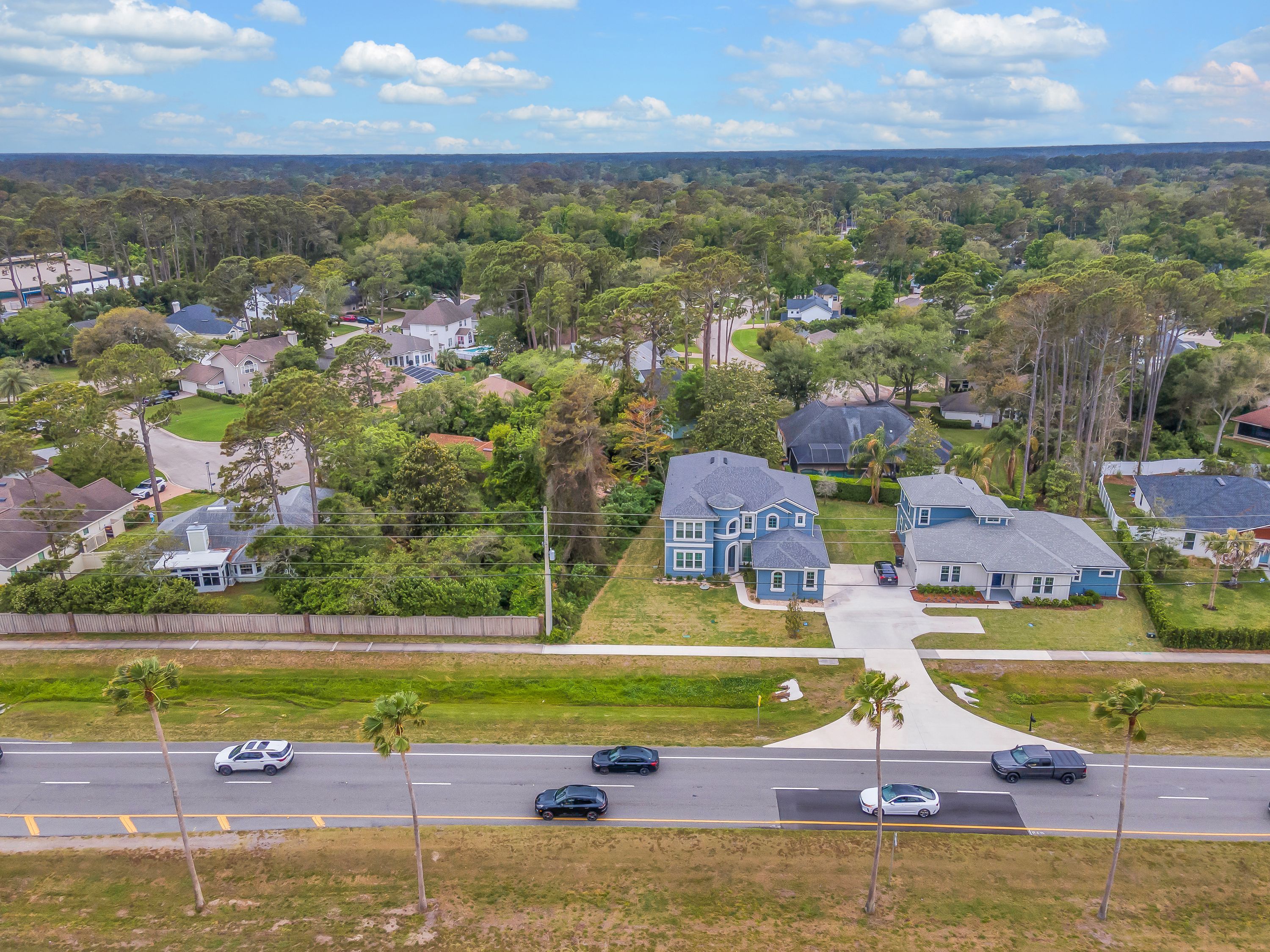 A residential area with houses, roads, and a clear sky.