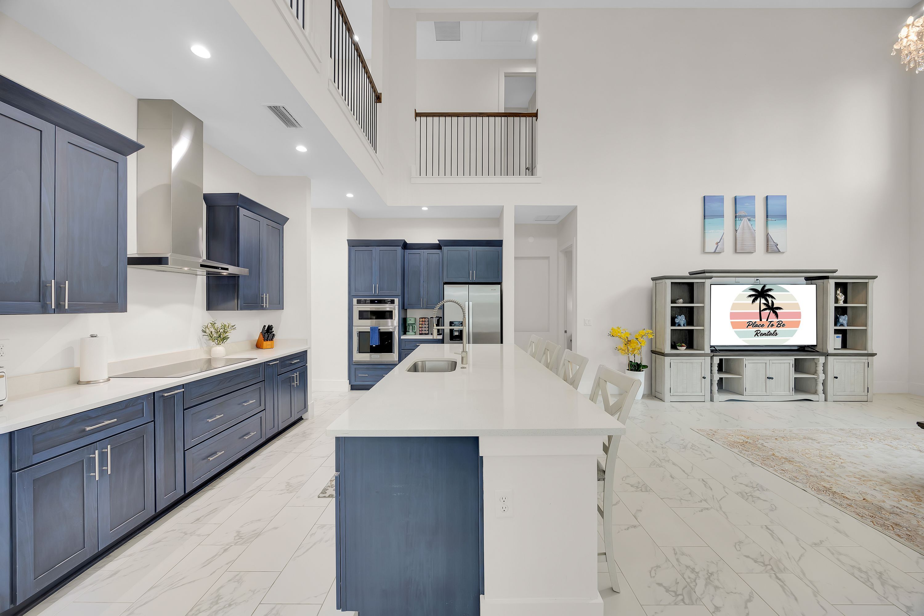 A modern kitchen with dark blue cabinets, a white countertop, and a central island.