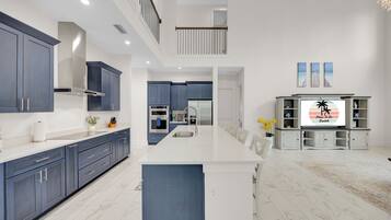 A modern kitchen with dark blue cabinets, a white countertop, and a central island.