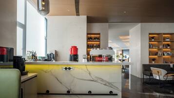 A modern kitchen with a marble countertop, a coffee machine, and a red PURUZE espresso machine.