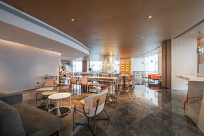 A spacious hotel lobby with a central bar area, multiple seating arrangements, and a modern design. - Jingju Hotel Shenzhen (Shenzhen)