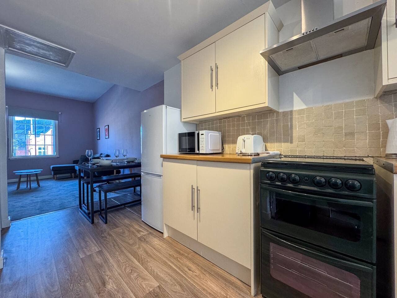 A compact kitchen with a stove, microwave, and cabinets.