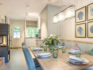 Un comedor moderno con una mesa de madera para cuatro personas, una chimenea y obras de arte enmarcadas en las paredes.
