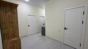 Un pasillo con puertas blancas y un armario de madera.