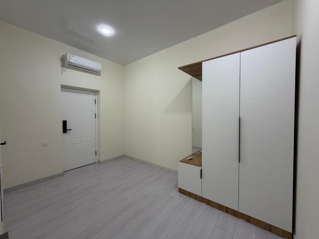 Una habitación con un armario blanco, una puerta y un equipo de aire acondicionado.