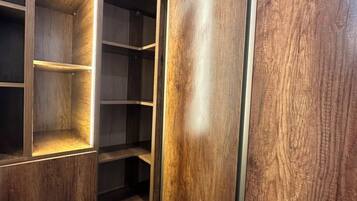 Un armario de madera con varios estantes y puerta corredera.