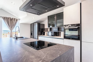 A modern kitchen with a built-in stove, microwave, and oven. - A2 - luxury apartment near beach with big terrace and the sea view (Kaštel Gomilica)