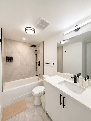 Ein modernes Badezimmer mit Badewanne, Toilette und Waschbecken.