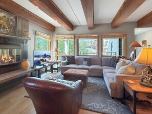 A cozy living room with a fireplace, a sofa set, and a television. - New Listing - Plaza 339 — Updated 3BR Base Area Condo (Crested Butte)