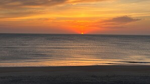 A sunset over a calm sea with a beach in the foreground. - JL S-2C Sands Condos - Oceanfront - Community Pool (Kill Devil Hills)