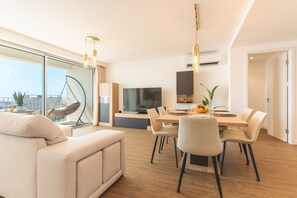 Un salon moderne comprenant un canapé, une table à manger, des chaises et un fauteuil suspendu.