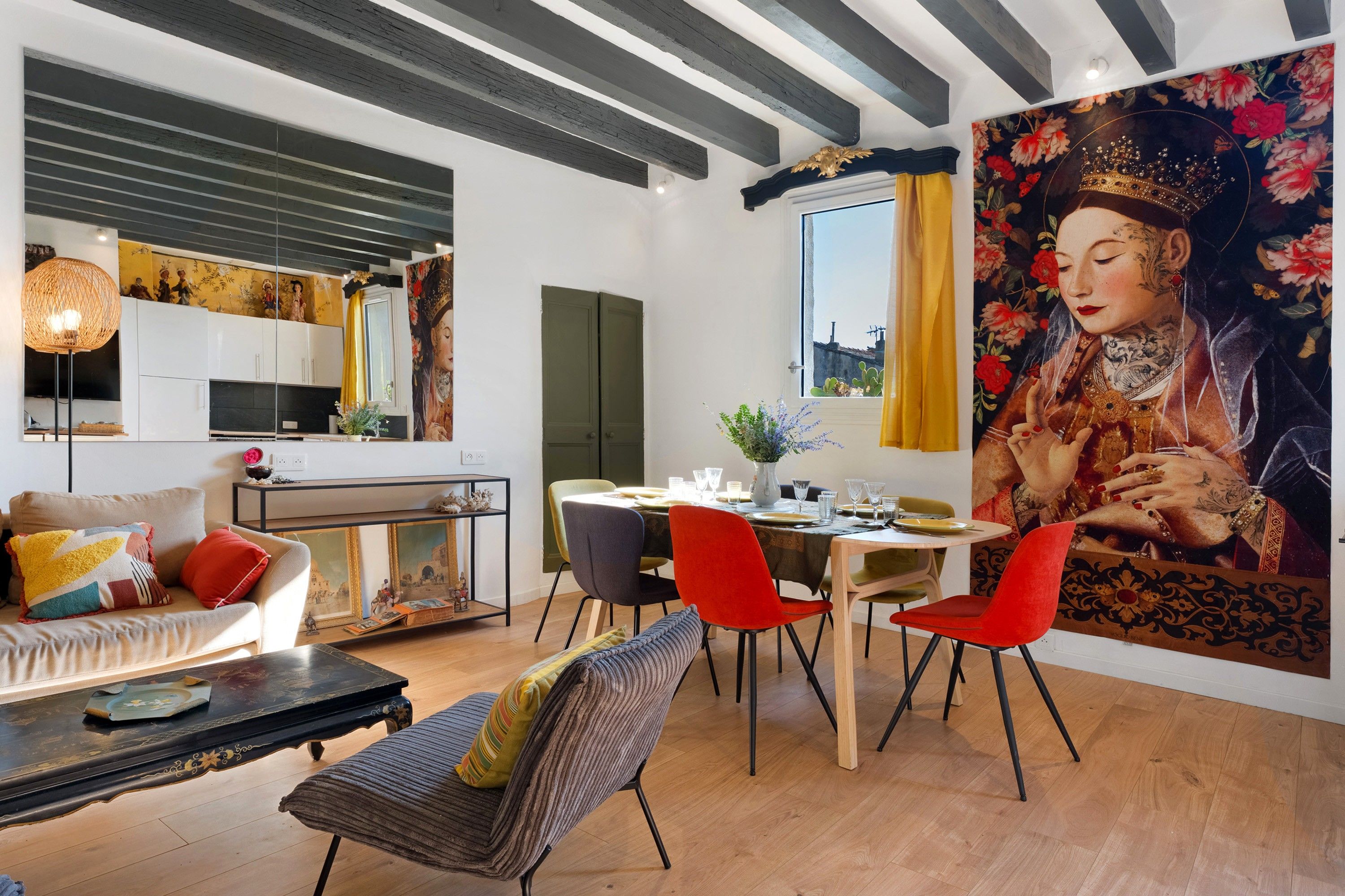 A modern living room with a dining area, a large painting on the wall, and a view of the cityscape through the window.