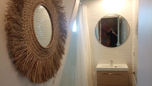 Et badeværelse med toilet, håndvask og spejl.