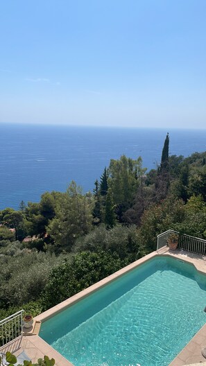 A clear blue pool with a view of the sea and surrounding greenery. - Villa with breathtaking views, a pool, a guest house, and air conditioning near Monaco (Roquebrune-Cap-Martin)