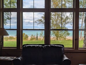 Una habitación con un amplio ventanal que ofrece vistas a la playa y al océano.