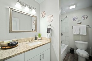 A bathroom with a sink, mirror, towel rack, and toilet. - Elegant 2BR Apartment right by Cowboys Stadium! (Arlington)