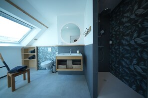 A modern bathroom with a skylight, a round mirror, a sink, and a shower. - The Kordokov vacation rental—a renovated old farmhouse near the sea, set in the heart of a stable (Tréméreuc)