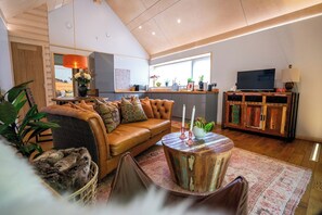 Una sala de estar moderna con un sofá de cuero, una mesa de centro y una televisión.