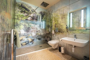Ein Badezimmer mit Duschkabine aus Glas, Toilette und Waschbecken.