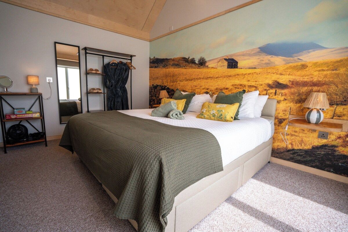 Un dormitorio con una cama, un espejo, un estante con zapatos y un mural de un paisaje.