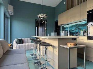 Una cucina moderna con angolo bar, divano e tavolo da pranzo.