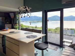 Una cucina moderna con vista su un lago e sulle montagne.