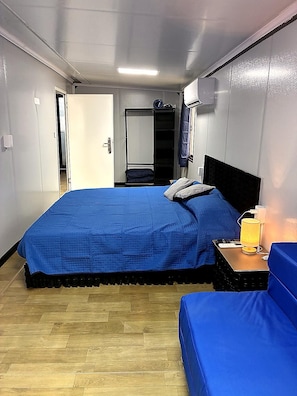 Ein Zimmer mit einem Bett, einem Nachttisch mit Lampe und einem Kleiderschrank.