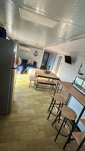 Eine moderne Küche mit Essbereich, Holzboden und Blick zum Wohnzimmer.