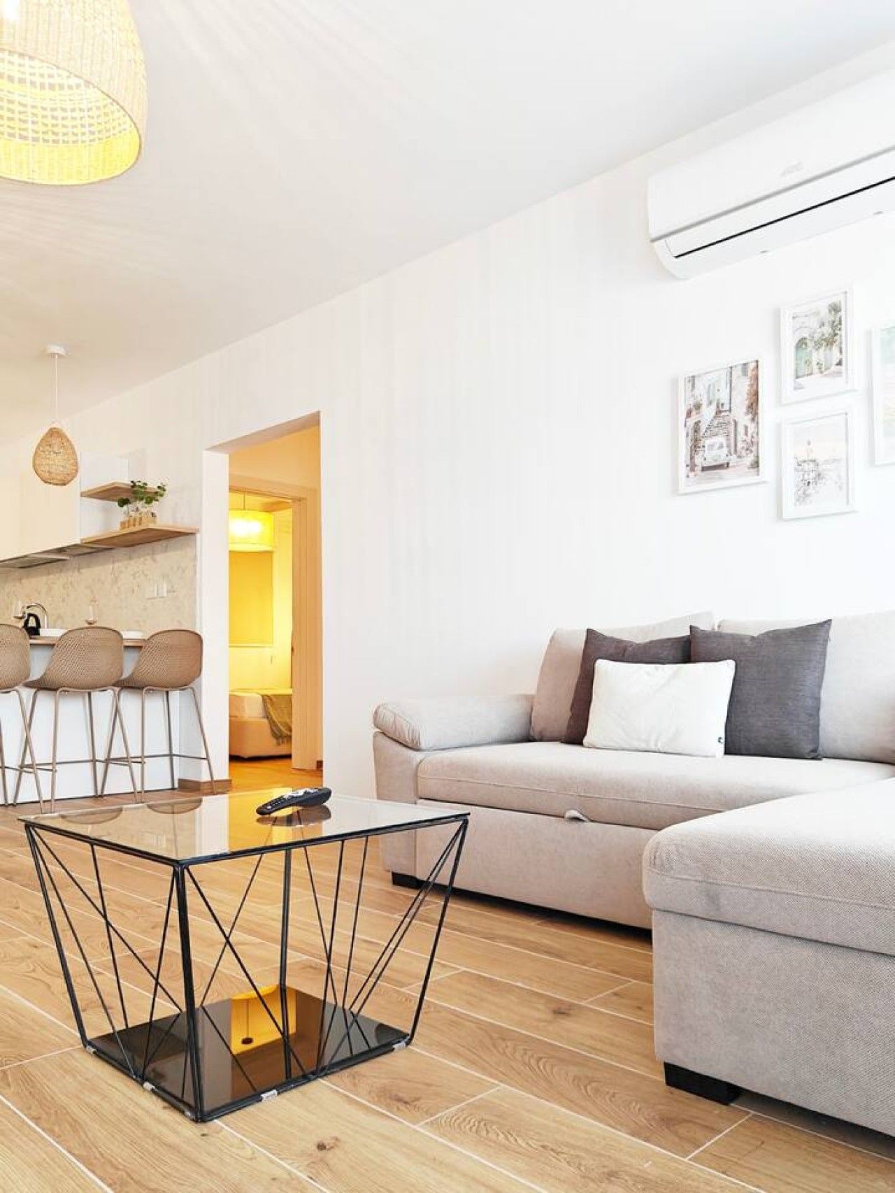 Ein modernes Wohnzimmer mit einer Couch, einem Glastisch und einem Essbereich mit Stühlen.