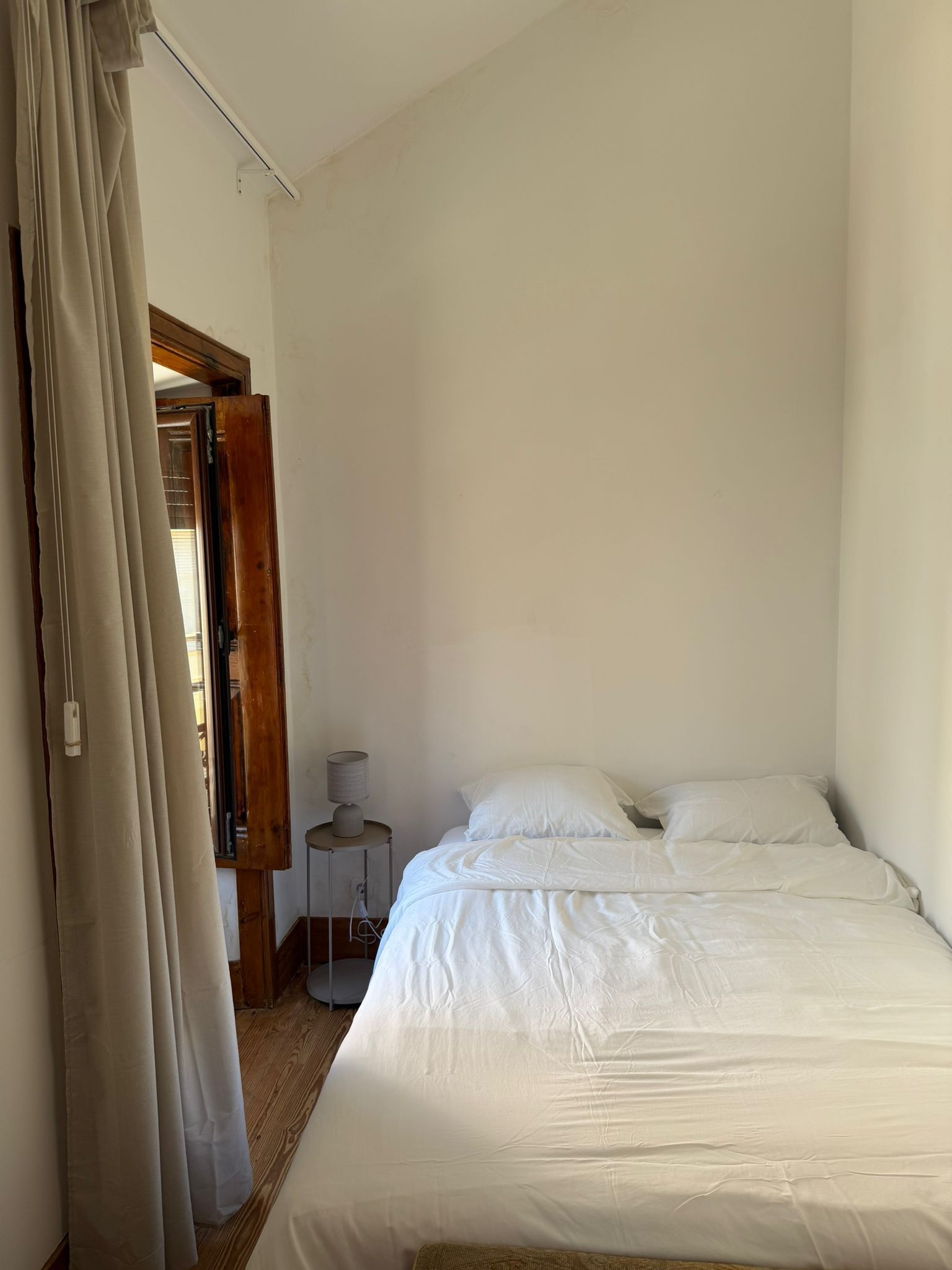 Une chambre à coucher avec un lit, une table de chevet et une lampe.
