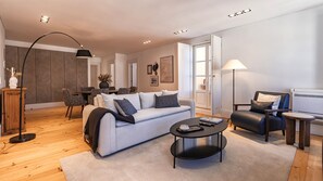 Ein modernes Wohnzimmer mit einer Couch, einem Couchtisch und einem Essbereich mit Stühlen.
