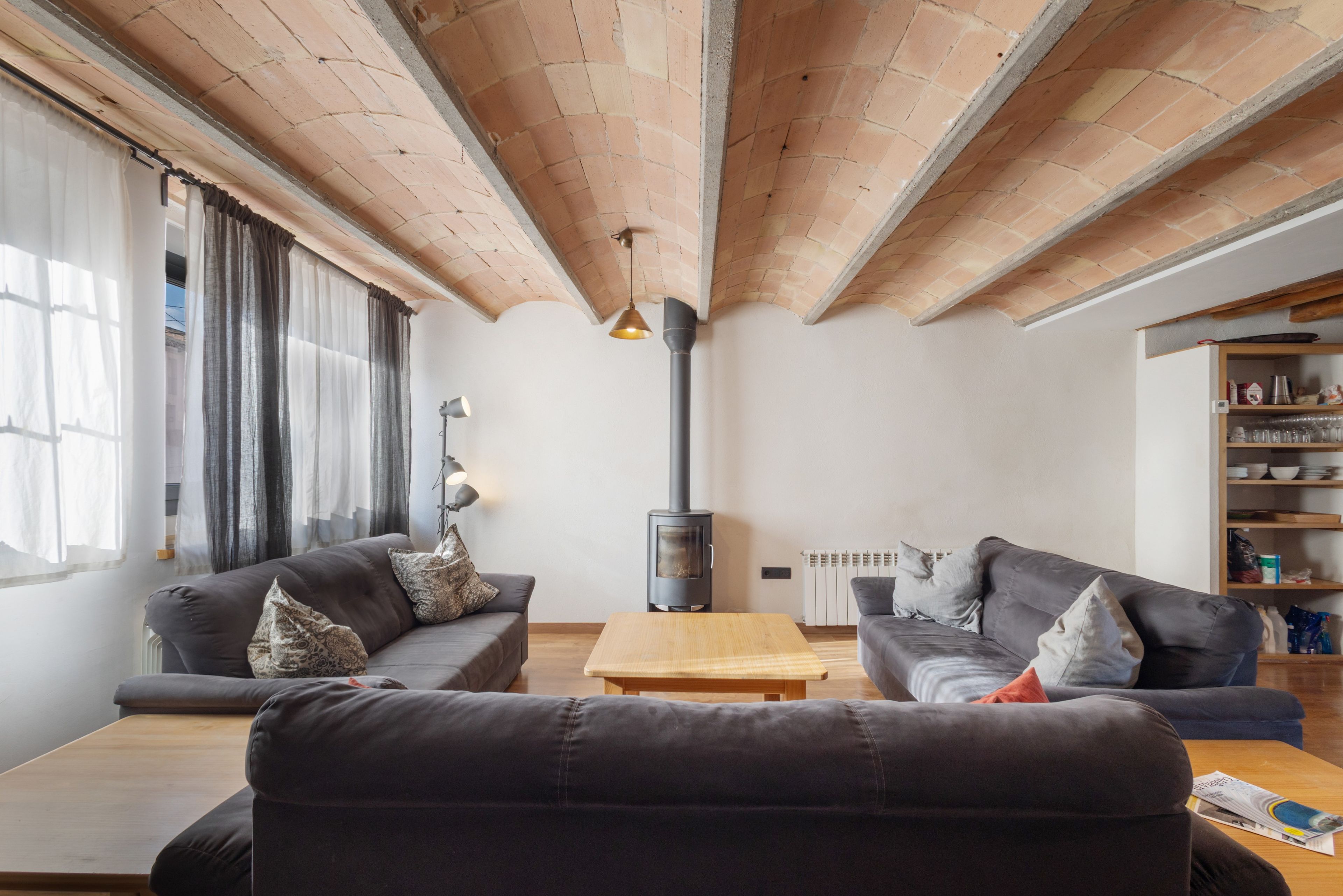 Una sala de estar con chimenea, dos sofás, una mesa de centro y una estantería.