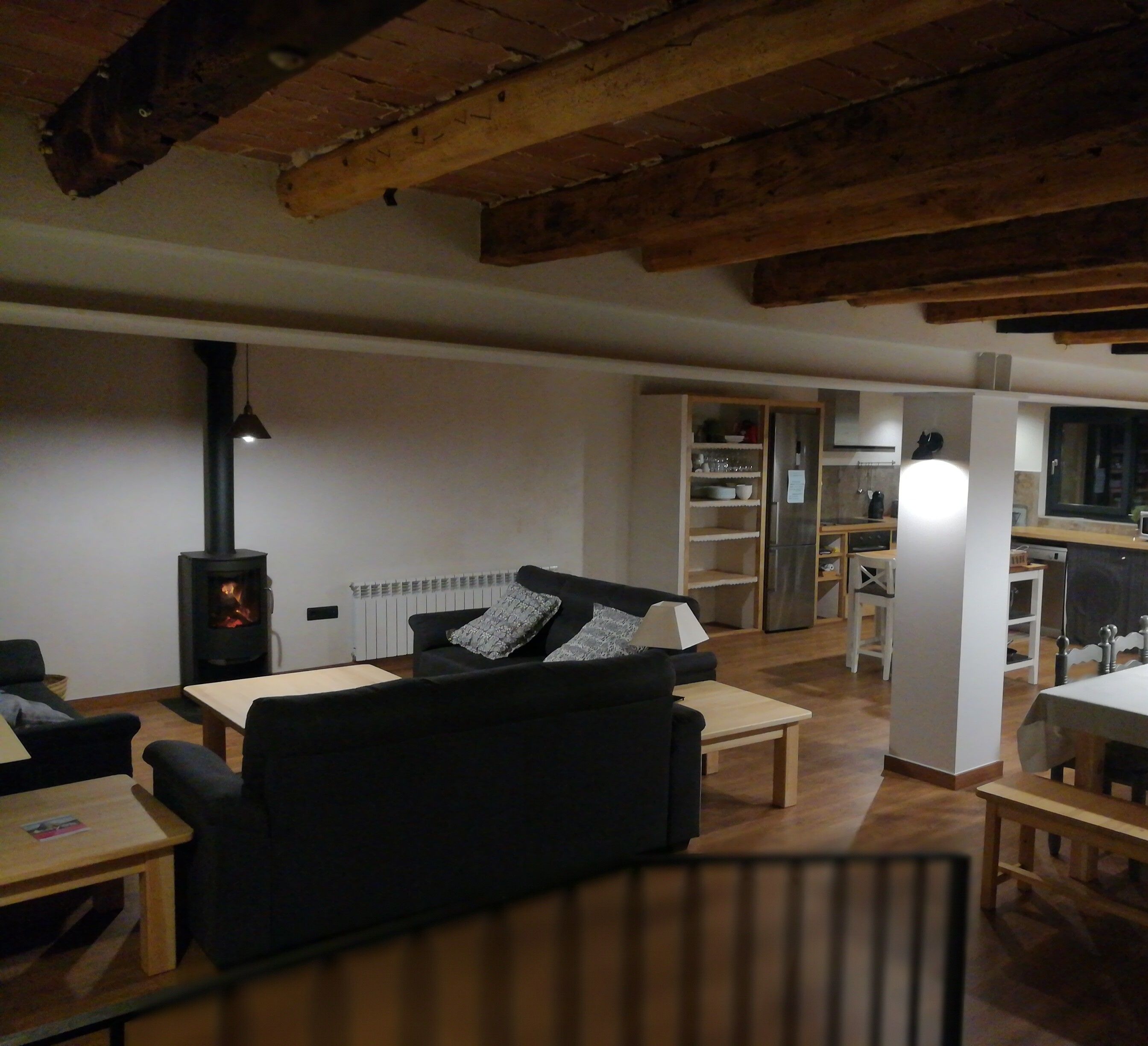 Una sala de estar acogedora con chimenea, un sofá y un comedor con mesa y sillas.
