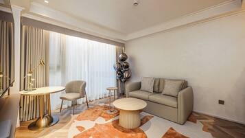A modern living room with a sofa, a round coffee table, a chair, and a small side table.