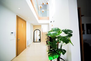 A modern interior with a wooden door, a large mirror, and a staircase leading to an upper level. - Villa Apollon: Seaside and Luxurious (La Marsa)