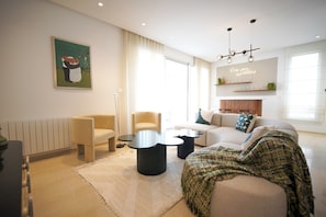 A modern living room with a sofa, armchairs, a coffee table, and a painting on the wall. - Villa Apollon: Seaside and Luxurious (La Marsa)