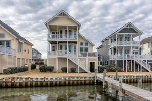 A waterfront property with multiple buildings featuring balconies and a dock.