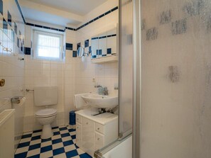 A bathroom with a toilet, sink, and a mirror. - Apartment 14 (St. Peter-Ording)
