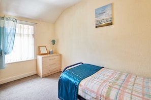 A bedroom with a bed, a dresser, a window with curtains, and a motivational quote on the wall. - Host & Stay | Norwood Street (Scarborough)