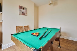 A pool table with balls and cues, wooden chairs, and a map on the wall. - Host & Stay | Norwood Street (Scarborough)